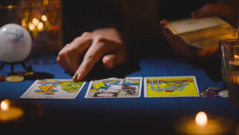 Close-Up-Of-Woman-Giving-Tarot-Card-Reading-On-Candlelit-Table-12